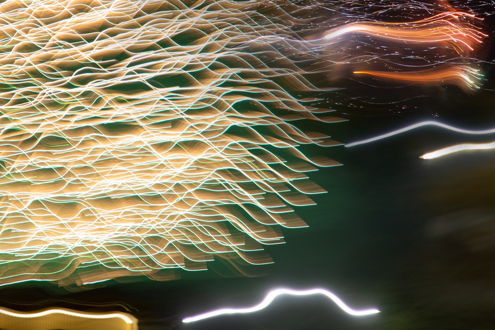 Long-exposure photograph of gold, green, and white firework light trails